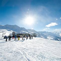 Skifahrer auf Skipiste bei strahlendem Sonnenschein