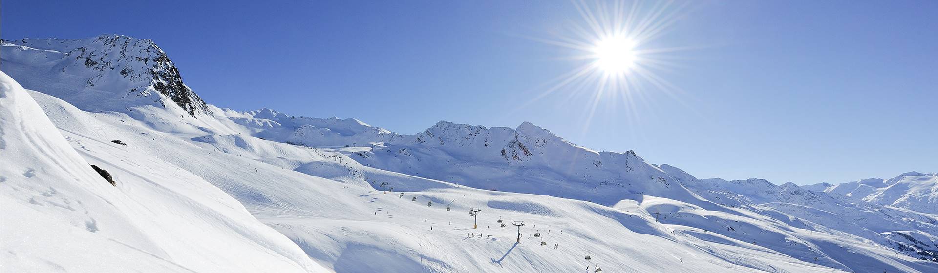 Ski area with lifts in bright sunshine