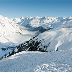 Skiabfahrt in Winterlandschaft vor schneebedeckten Bergen